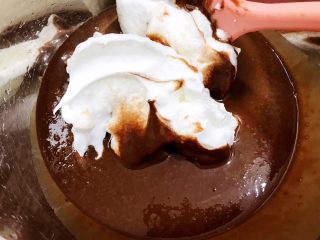 7、可可戚风蛋糕,先加入两勺蛋白跟蛋黄糊用翻拌的手法混合均匀