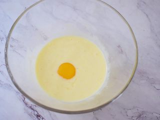 5、酸奶蛋糕（黄油版）,加入蛋黄，注意一次一个蛋黄，搅拌均匀后再加入另一个蛋黄继续搅拌均匀