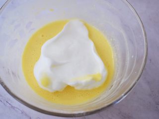 11、酸奶蛋糕（黄油版）,将三分之一的蛋白霜加入蛋黄中，翻拌均匀