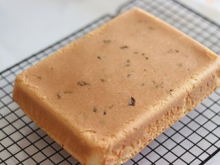 12、椰蓉戚风蛋糕,出炉放到晾网上。倒扣到晾网上，撕去油纸晾凉。