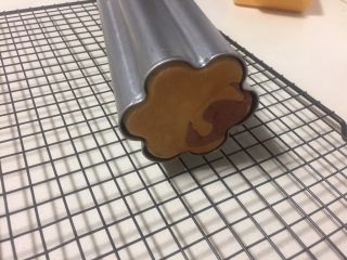 11、紫薯原味拼色梅花吐司（中种法）,烘烤结束取出来，拿掉两头的盖子倒出面包在晾网架上散热。