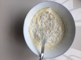 5、肉松小贝,把低粉过筛加入蛋黄液中