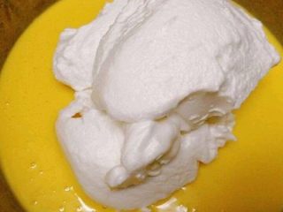 15、7寸中空戚风蛋糕(新手零失败),先加入二分之一打发好的蛋清,用画Z字的方式充分搅拌均匀