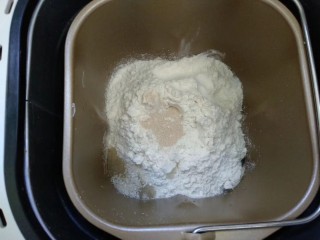 2、法式面包,面团材料放入面包桶，糖和盐对角放，中间挖个坑放入酵母，启动面包机揉面。