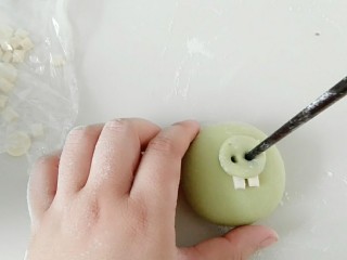 8、绿皮捣蛋猪奶黄花样餐包,粘上牙齿，然后放上猪鼻子，筷子戳出鼻孔。