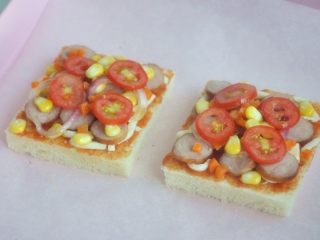 18、香肠吐司披萨,将香肠、玉米、洋葱、圣女果、胡萝卜放在吐司片上。