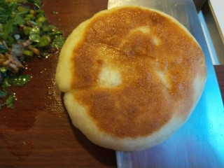 25、腊汁肉夹馍,快刀在饼中间片开。