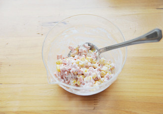 4、时下超级火爆的萌哒哒面包【面包超人挤挤面包】,发酵面团时制作馅料，将火腿肠切成丁与熟玉米粒一起放入碗中，加入沙拉酱拌匀；