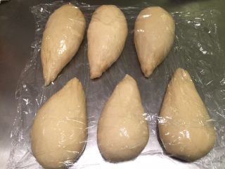 7、牛角汉堡,将面团平均分成6份,搓成水滴状,盖上保鲜膜松弛15分钟