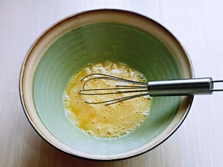 3、黑芝麻玛德琳蛋糕,用手动打蛋器，打至均匀，再加入纯牛奶，充分搅拌融合。