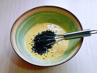 6、黑芝麻玛德琳蛋糕,再加入熟黑芝麻，手动打蛋器打至均匀。(建议使用熟芝麻，熟的芝麻口感更香)