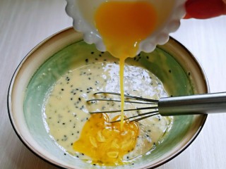9、黑芝麻玛德琳蛋糕,加入融化的黄油液，充分拌均匀，再加入玉米油再次拌均匀，避免油水分离现象，所以一定要充分拌均匀后再加入剩下的玉米油。(全部用黄油也可以，但不建议全部用玉米油，少了黄油口感上会差那么一点点)