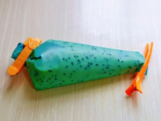 11、黑芝麻玛德琳蛋糕,装入裱花袋中，用夹子将其夹紧！放冰箱冷藏室1小时。