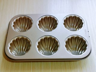 12、黑芝麻玛德琳蛋糕,模具中刷上一层薄薄的玉米油，将蛋糕糊从冰箱取出室温放置2分钟。