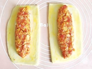 9、千层酥皮香肠卷,将从冰箱里拿出来的肉馅儿，适当地搓成长条，去掉保鲜膜，放在面皮中间，面皮四周刷鸡蛋液，便于粘合