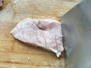 4、炸猪排,用刀背拍肉，然后轻轻的把肉剁松，横竖和翻面都需要这样加工一下。