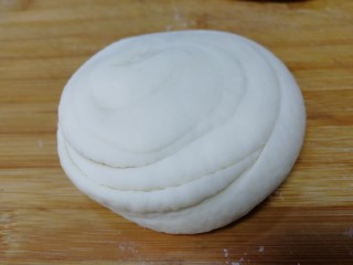12、家常烫面饼,压扁，保鲜膜密封饧发10分钟。