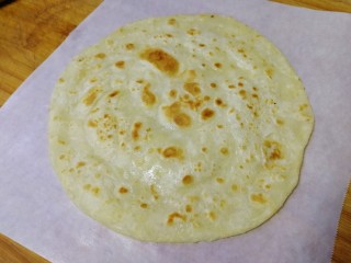 16、家常烫面饼,烙好放在油纸上，外皮酥脆，里面柔软又劲道。