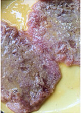 5、黄金炸猪排,将一只鸡蛋打散倒入盘子里，将肉片两面都均匀地沾满蛋液