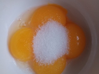 1、送你一朵小红花,来做蛋糕胚。把鸡蛋蛋黄蛋白分离，蛋黄加入10克糖，搅拌到糖融化