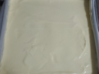 9、送你一朵小红花,面糊倒入方形烤盘中，最好垫上烘焙纸。用刮刀把面糊表面刮刮平。震一下大气泡