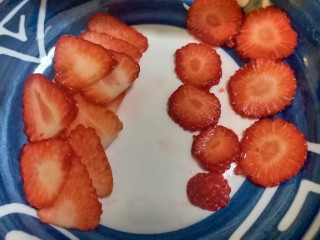 13、送你一朵小红花,把草莓切成圆片，用来做小红花。切三角形片是贴着包装盒摆的。剩下的切丁，夹在淡奶油中。