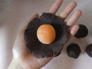 2、蛋黄酥黄油版,然后将豆沙擀开,将咸蛋黄放进豆沙里。(我是直接买的熟的咸鸭蛋敲出来的蛋黄)