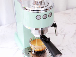 2、咖啡奶油蛋糕卷,首先先制作咖啡液,先把咖啡粉放入马克西姆意式咖啡机中,萃取咖啡后放凉备用