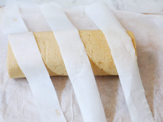 22、咖啡奶油蛋糕卷,定型后,用油纸剪出三条一样大小的油纸条,码在蛋糕卷上,留出一样宽的空隙