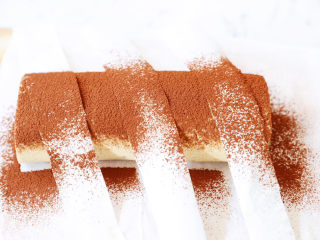 23、咖啡奶油蛋糕卷,然后用筛上可可粉,筛好后轻轻地将油纸移开,移的时候要小心点,以免可可粉散