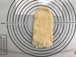 9、芝麻软面包,取一面团,按扁后擀成长舌形,拍去边上空气。翻面,底部压薄。