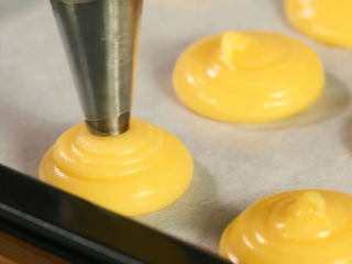 14、香草泡芙,然后把泡芙面糊挤入烤盘中，每个大概是5厘米，如果要做大泡芙就挤大一点，面糊一定要有硬度，否则是烤不了大泡芙