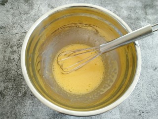 5、可可戚风蛋糕,用打蛋抽把蛋黄、牛奶、玉米油、白砂糖打至完全融合 蛋黄颜色变浅 看不到油星即可。