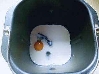 2、原味吐司,将牛奶倒入面包桶，再加入鸡蛋。