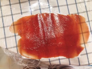 12、猪肉脯-零食、年货,表面铺上一层保鲜膜，用擀面仗擀成一块薄薄的肉片。