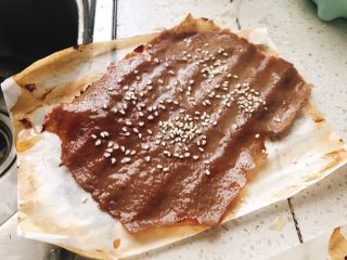 15、猪肉脯-零食、年货,取出肉脯，两面都刷上一层蜂蜜，并撒上少许白芝麻。