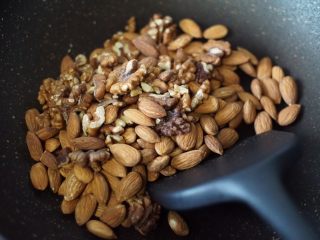 2、奥利奥雪花酥,巴坦木和核桃仁放入锅里炒香