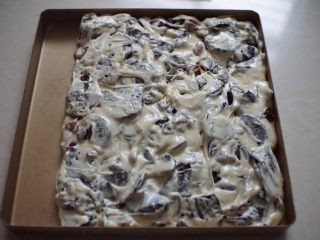 8、奥利奥雪花酥,再翻拌均匀的糖倒入烤盘里，用锅铲轻轻压实压平