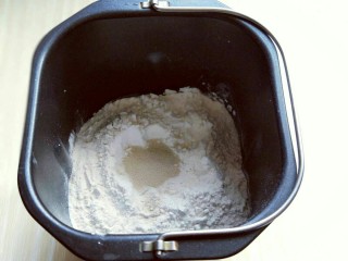 4、最爱面包+椰蓉面包,加入鸡蛋(鸡蛋重量约50g左右)再放入面粉，当中挖个洞，放入酵母粉，再用旁边的面粉将酵母粉盖起来。