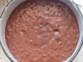 8、黑森林,把翻拌好的面糊倒入铺了油纸的6寸圆形模具中，震出大气泡