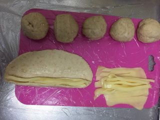 5、燕麦芝士贝果～,将芝士丝平铺在面皮边缘，放好，这里我放的太多了，建议少放一点～