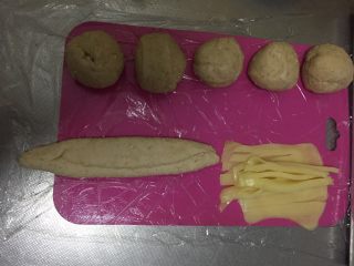6、燕麦芝士贝果～,从两侧1/3处分别折叠，然后将尾部压紧，防止芝士烤的时候流出来～同时把裹好的面条搓成20cm左右的长条～注意不要错漏哦～