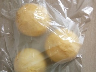 8、超软白米粥吐司,醒发结束，将面团取出按压排掉汽包，分成3等份的面团滚圆，盖上保鲜膜松弛20分钟。