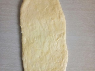 9、超软白米粥吐司,取松施好的面团用擀面仗擀成椭圆形。