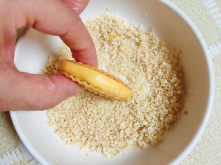 14、南瓜糯米薯片饼,将夹心饼在白芝麻碗中滚一下，粘上一圈白芝麻。