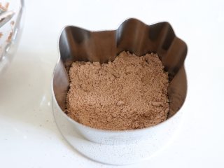 5、HelloKT蒸米糕,又萌又美味,全部筛完后,准备好模具,用到了慕斯模具,底部可以档一个平的盘子,然后用勺子挖出棕色的粉,到容器中。