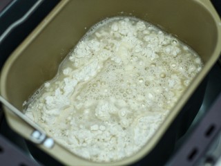3、东北猪肉酸菜馅包子,将酵母水和剩下的温水一同倒入面粉中