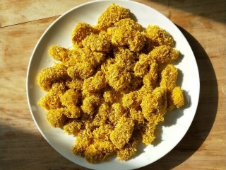 7、油炸劲辣香酥鸡米花,逐一裹好放餐盘中。