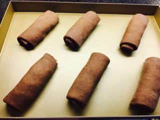 16、网红脏脏包（开酥版）,卷好后，放置于烤盘内，进行发酵。因为开酥包裹的黄油。发酵温度不可过高。温度不要超过30度。发酵时间大概2个小时。发酵至体积变大。烤箱180度，中下层，13到15分钟。亦可，上火170，底火200度。13到15分钟，具体根据自己烤箱调节。