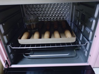 15、吃一次就会爱上它的美～可可酸奶面包,放入烤箱中进行二次发酵，在烤盘中间放一杯开水，保持面团湿度！